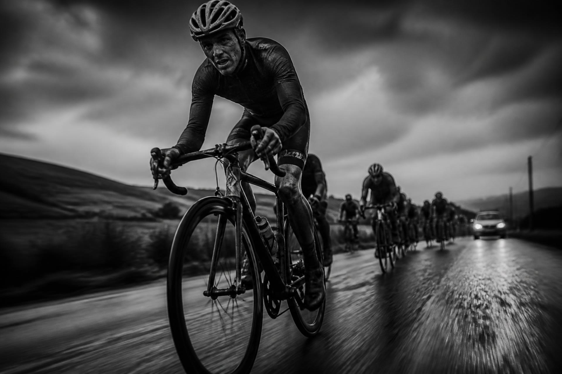 Road cyclist leading a breakaway on wet tarmac